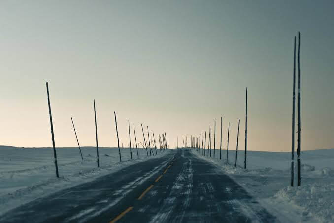 Convoi de véhicules sur une route hivernale en Norvège.
